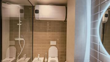 A modern bathroom with a shower, bidet, and toilet.