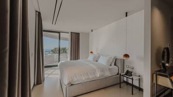 Een moderne hotelkamer met een groot bed, een bureau met telefoon en uitzicht op de omgeving.