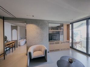 Un interior moderno con una zona de estar, cocina integrada y un amplio ventanal.