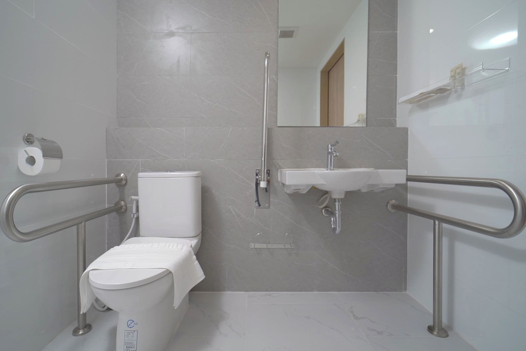 Une salle de bain avec des toilettes, un lavabo et une douche.