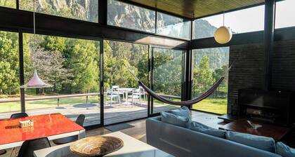 Luxury house in the mountains surrounded by nature and rock cliffs.