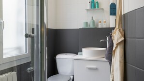 A bathroom with a toilet, sink, and shower area. - Charming Room in the Heart of Chartrons (Bordeaux)