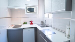 A compact kitchen with a microwave, sink, and dishwasher. - Central renovated studio - Stay in Granada (Granada)