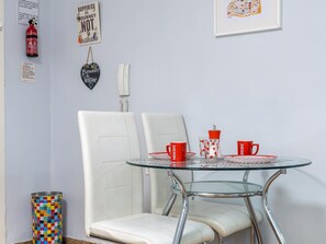A room with a glass table, two white chairs, red and white Nescafé cups, a fire extinguisher, and a framed map. - Central renovated studio - Stay in Granada (Granada)