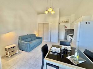 A compact living space with a sofa, dining table, and kitchen area. - Studio with AC, sea view - 2 guests (Casaglione-Tiuccia)