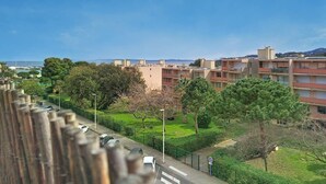 A residential area with multi-story buildings, a clear sky, and a road with parked cars. - Duplex with AC, sea view - 5 guests (Bormes-les-Mimosas)