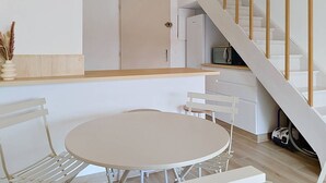 A modern kitchen with white cabinets, a microwave, and a vacuum cleaner. - Duplex with AC, sea view - 5 guests (Bormes-les-Mimosas)