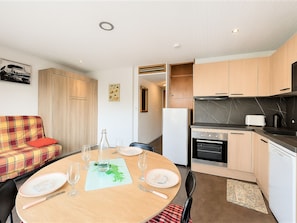 A compact living space with a dining area, kitchenette, and a sofa. - Studio for 4 guests, center station south (La Toussuire)