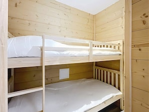 A bunk bed room with wooden walls and a white door. - Studio for 4 guests, center station south (La Toussuire)