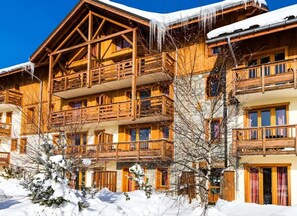 A multi-story wooden chalet with balconies, surrounded by snow. - Calm apartment, balcony with view - 6 guests (La Toussuire)
