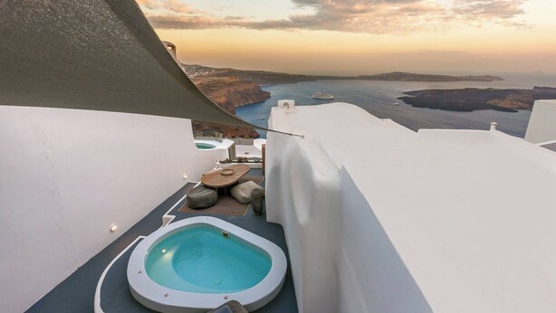 A rooftop pool area with a view of the sea and islands. - Pura Vida Cave House (Santorini)
