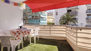 A balcony with a table, chairs, and a red umbrella. - Apartment 'Salou Beach' with Sea View, Wi-Fi, and Air Conditioning (Salou)