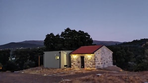 A small stone building with a red roof, a grey structure next to it, and a mountainous backdrop. - Retreat in Beira Interior, private outdoor jacuzzi, AC and breakfast!!! (Telhado)