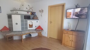 Olohuoneessa on seinään integroitu viihdekeskus, puinen kaappi ja seinälle asennettu televisio.
