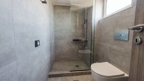 Ein modernes Badezimmer mit einer Duschkabine, einer Toilette und einem Handtuchhalter.