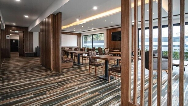 A spacious conference room with wooden paneling, tables, and chairs. - Zenith Hotel Frankfurt Airport  (Kelsterbach)
