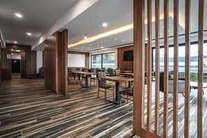 Ein geräumiger Konferenzraum mit Holzvertäfelung, Tischen und Stühlen.