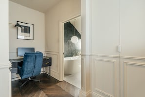 Een moderne kamer met een bureau, stoel en een groot raam.