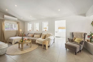 A spacious living room with a sofa, armchair, and a small wooden table with a candle. - Luxury spacious detached villa with private pool, large terrace and 7 bedrooms! (Gata de Gorgos)