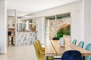 Una cocina moderna con una pared de piedra y un rincón de comedor con una mesa y sillas de madera.