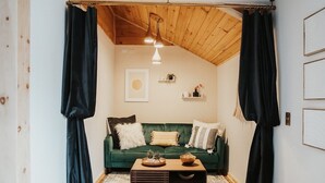 A cozy living room with a green sofa, a wooden coffee table, and a ceiling fan. - Finger Lakes Renovated Farmhouse + Maple Farm! (Montour Falls)