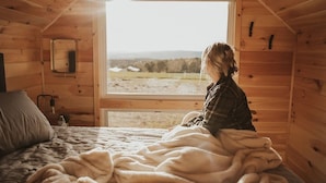 Une pièce confortable avec un lit, une fenêtre et une vue sur l’extérieur.