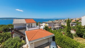 A coastal residential area with houses, a clear blue sky, and a view of the sea. - Very nice studio apartment with sea view, balcony & parking space (Crikvenica)