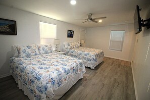 A bedroom with two beds, a ceiling fan, and a window with blinds. - Newly remodeled home where the wildlife roam! (Port Mansfield)