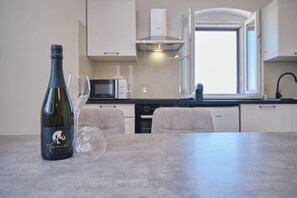 A kitchen with a wine bottle and glasses on the counter. - Adriatic Shell Apartment #2 (Okrug Gornji)