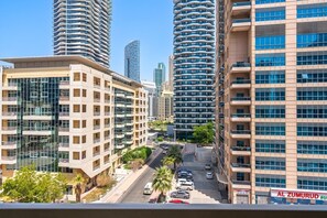 Ein hoch aufragendes Stadtgebiet mit modernen Gebäuden, blauem Himmel und einer Straße mit parkenden Autos.
