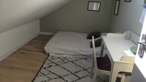 A small, sloped room with a bed, a desk, and a chair. - House between Nantes and Pornic (Sainte-Pazanne)