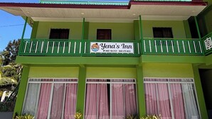 A two-story building with a green facade, balconies with white railings, and a sign for 'Yena's Inn' with contact numbers. - Yena's Inn (Cauayan)