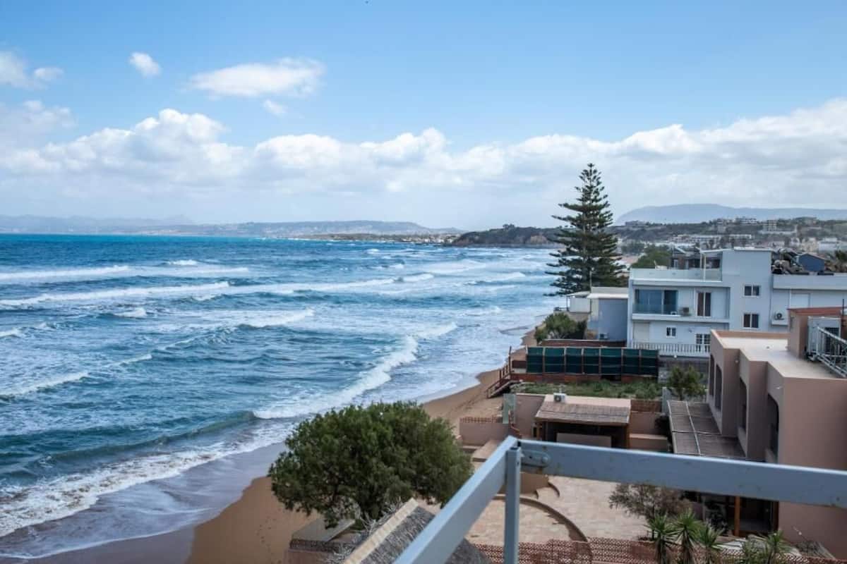 Vista costera con playa, océano y edificios residenciales.
