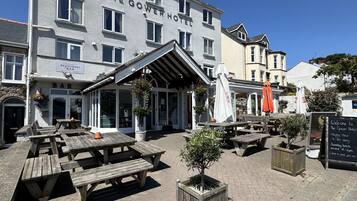 A hotel with outdoor seating and a sign for a restaurant.