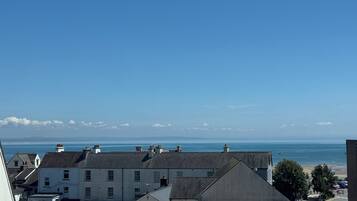 A coastal town with buildings, a clear sky, and the sea in the background.