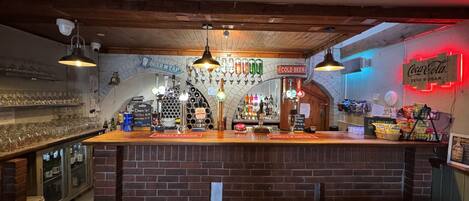 A bar with a brick counter, beer taps, and a Coca-Cola sign.