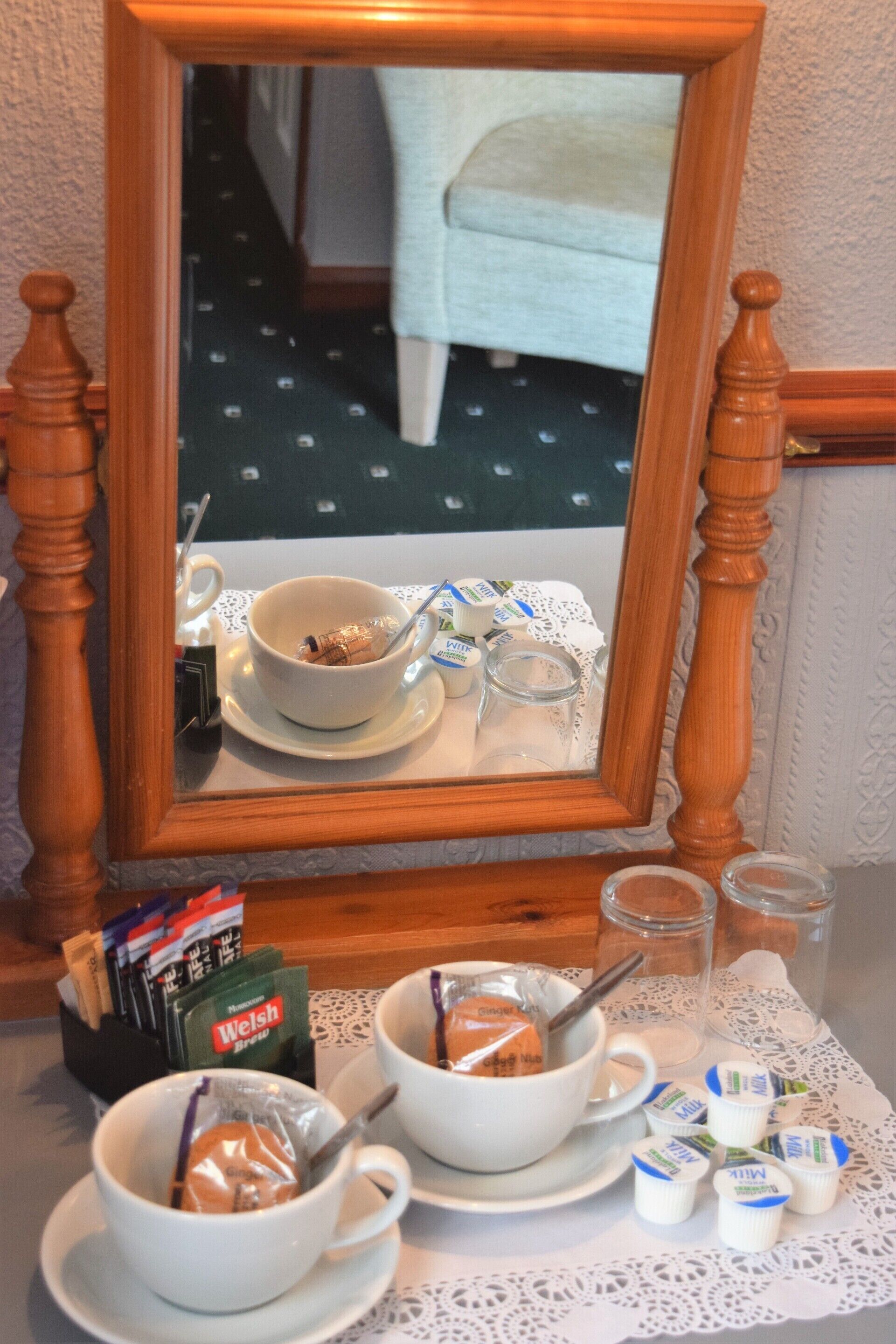 A breakfast setup with bowls, cups, and milk packets on a table with a lace doily.