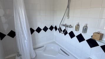Une salle de bain équipée d’une baignoire, d’une douche, d’un lavabo et de toilettes.