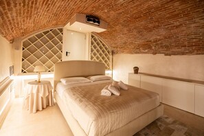 A bedroom with a brick ceiling, a large bed, a bedside table with a lamp, and a wardrobe. - Historic, elegant and modern residence on 3 floors (Verona)