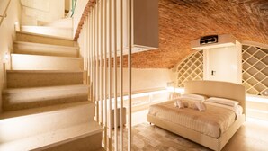A bedroom with a bed, a staircase, and a brick ceiling. - Historic, elegant and modern residence on 3 floors (Verona)