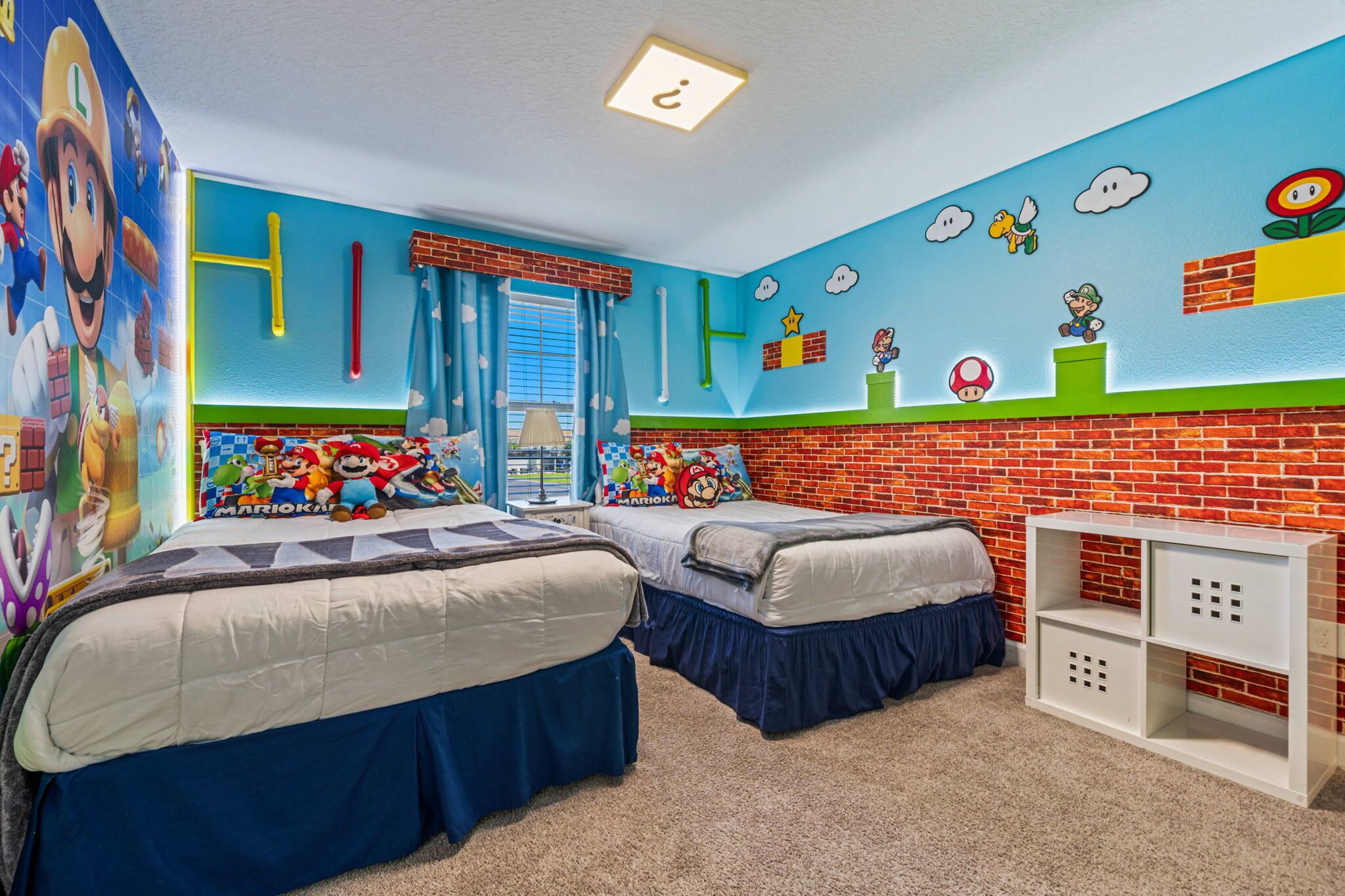 Ein Zimmer mit zwei Betten, einer Wand mit Ziegeloptik und einer Deckenleuchte.