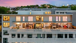 A multi-story hotel with balconies, large windows, and a rooftop terrace. - New Walk to Gulch - Private Penthouse Pool Deck Views (Nashville)