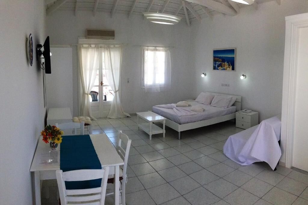 A bedroom with a bed, bedside table, and a desk with a chair.