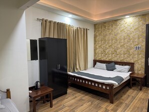 Une chambre à coucher avec un lit, une armoire, une table de chevet et un mur décoré d’un motif.