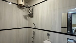 Ett badrum med toalett, bidé, handfat och en spegel.