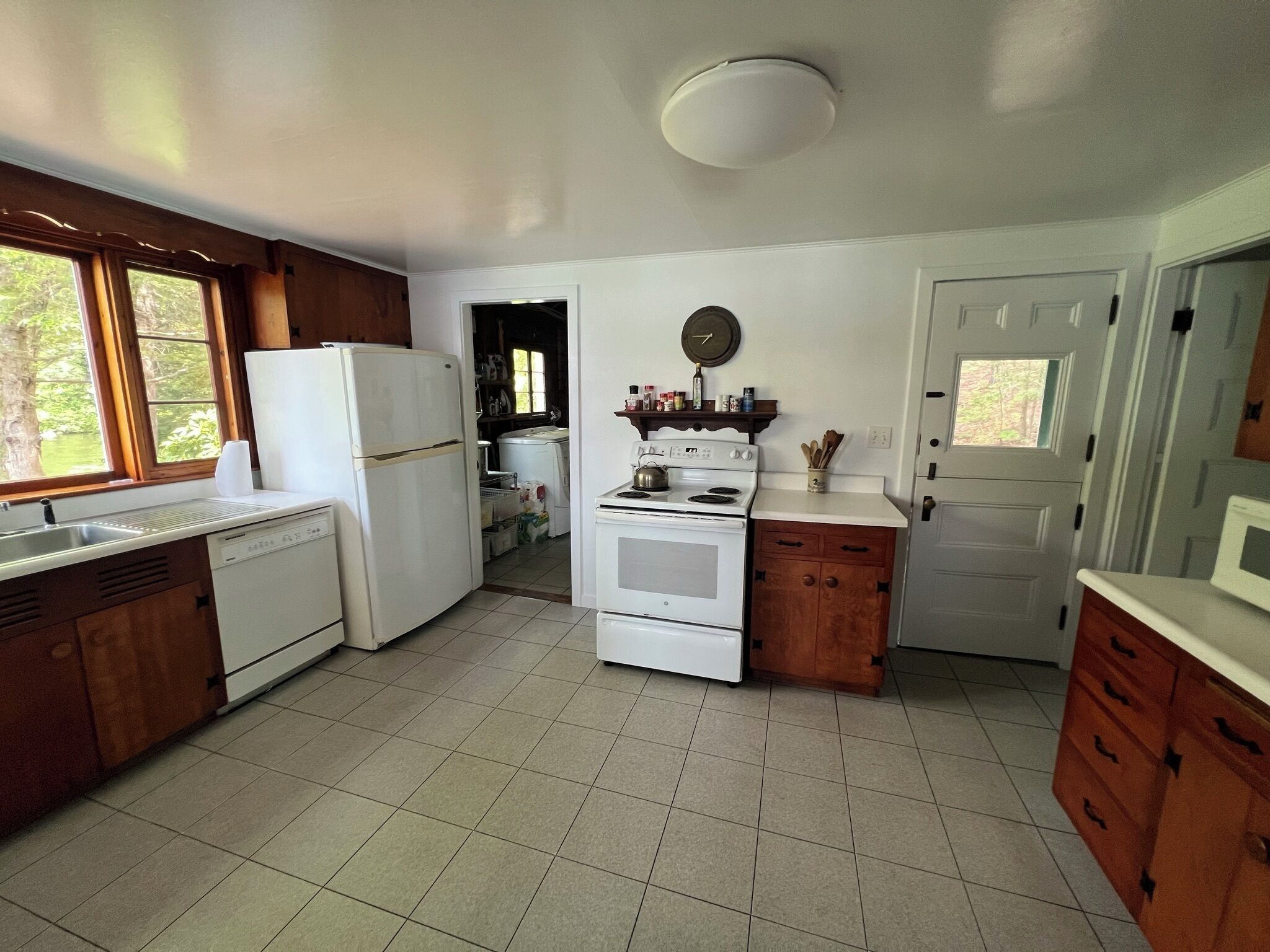 A kitchen with a refrigerator, stove, and wooden cabinets.