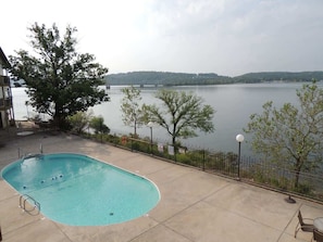 Une piscine avec vue sur un lac et des collines en arrière-plan.