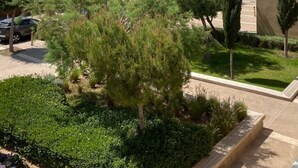 A residential area with a clear view of the sea, a parking lot, and a building with a flat roof. - Magnificent Duplex Sea View in Taghazout Bay (Taghazout)
