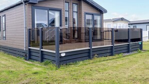 A modern mobile home with a deck, large windows, and a flat roof. - 8 Summerleaze (Bude)