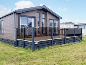 Una casa móvil moderna con terraza, ventanas amplias y techo plano.